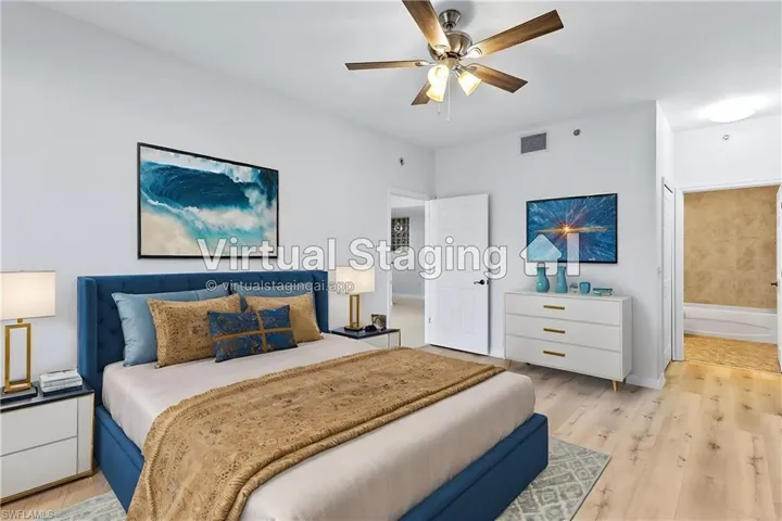 Bedroom with light wood-type flooring, ceiling fan, and connected bathroom