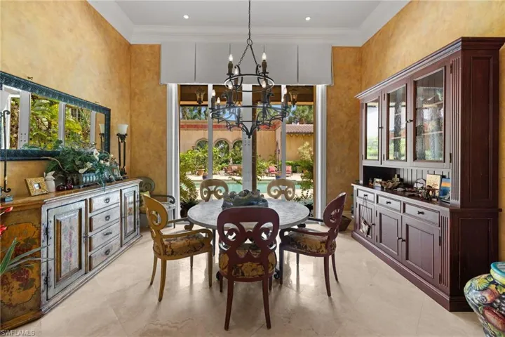 Dining area featuring a full-height window with pool and arched courtyard views