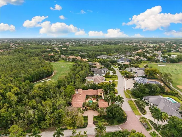 Expansive aerial showcasing a Mediterranean-style residence with a terracotta tile roof and mature landscaping