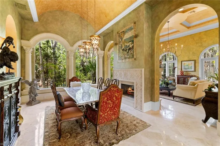 Dining area featuring a barrel vault ceiling with crown molding and polished stone flooring