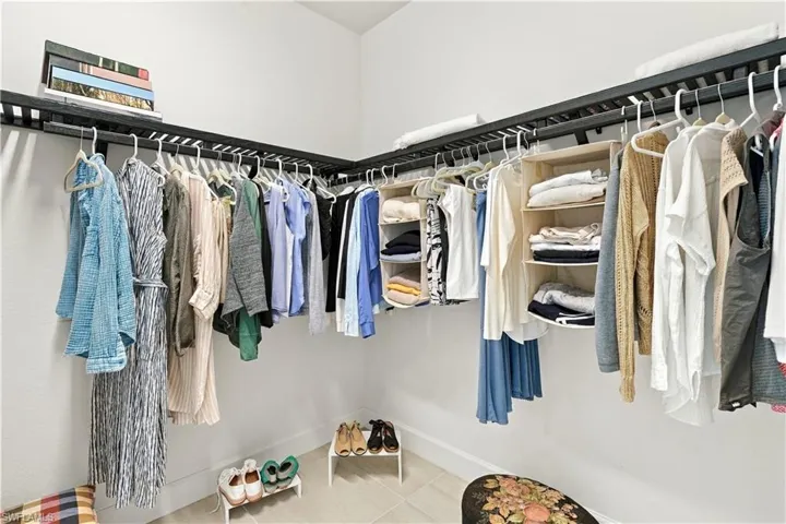 White walls with built-in dark wood shelving and hanging rods