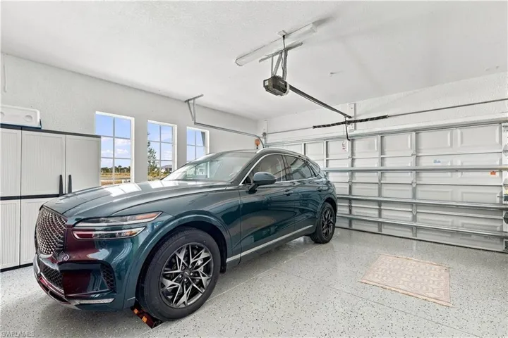 Two-car garage with an epoxy-coated floor, overhead door, and three transom windows