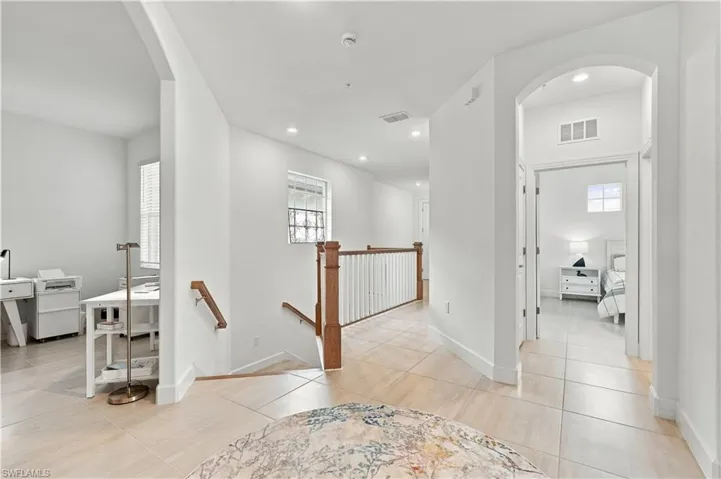 Hallway with light-toned tiled flooring, recessed lighting, and white walls