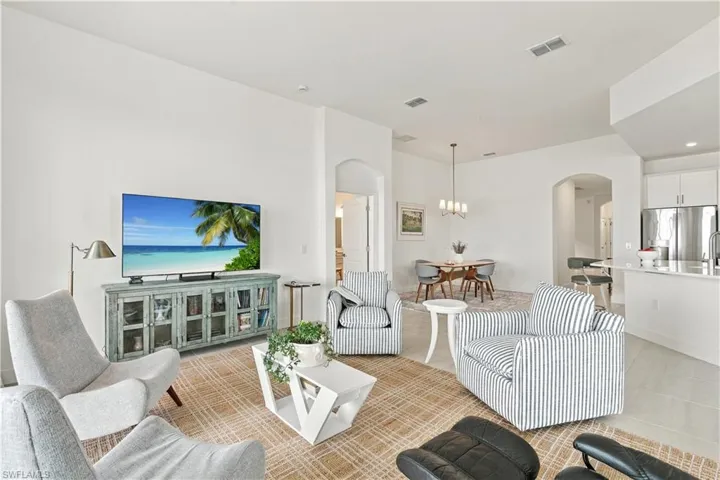 Open-concept living space featuring high ceilings, arched doorways, and tile flooring