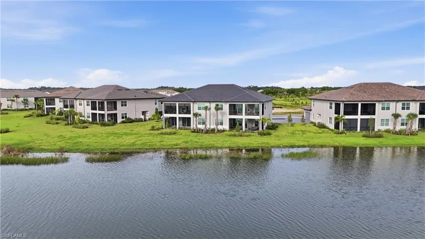 Lakefront property featuring a spacious grass lawn