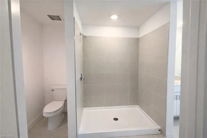 Full bathroom with a stall shower and light tile patterned floors