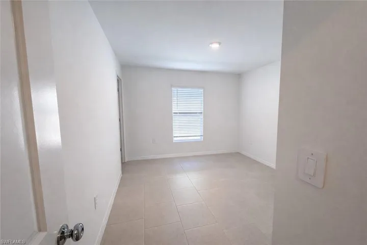 Empty room with baseboards and light tile patterned floors
