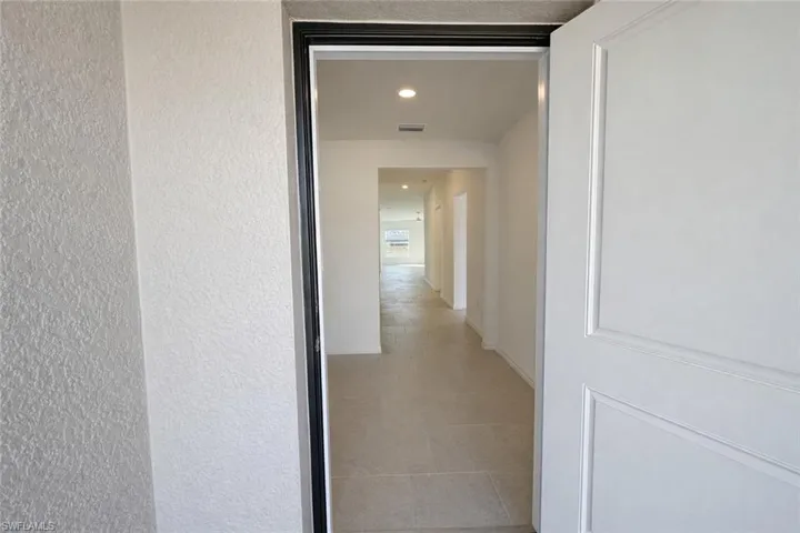 Hall with recessed lighting and light tile patterned floors