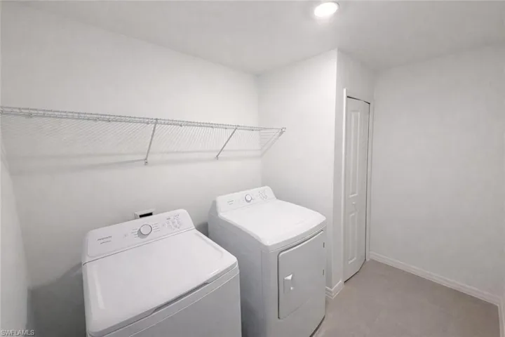 Laundry area with independent washer and dryer and baseboards