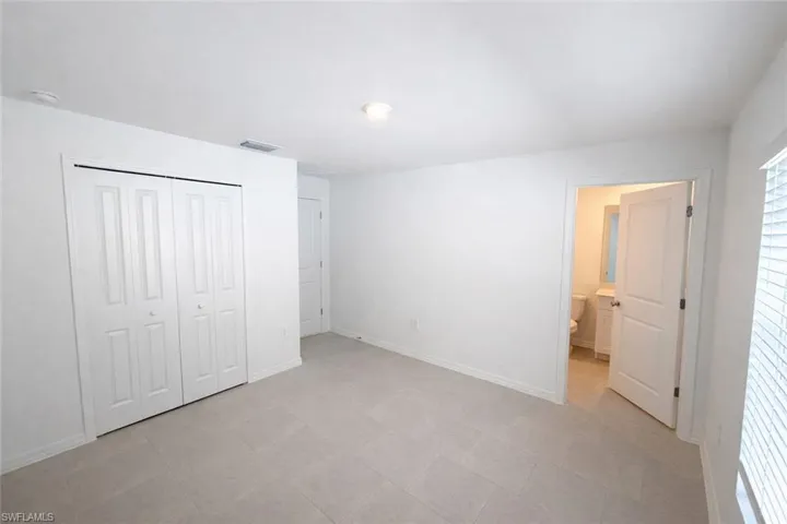 Unfurnished bedroom featuring a closet and ensuite bathroom