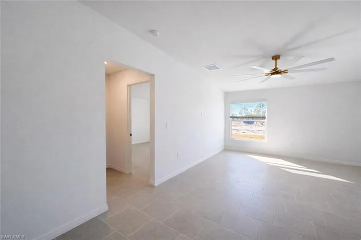 Empty room featuring ceiling fan and light tile patterned flooring