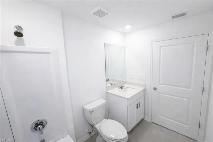 Bathroom with vanity, bathing tub / shower combination, and light tile patterned flooring