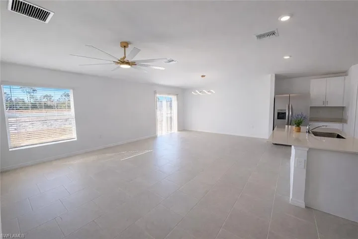 Unfurnished living room with a ceiling fan, light tile patterned floors, and recessed lighting