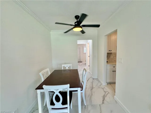 Dining area featuring ornamental molding, ceiling fan, and light tile floors