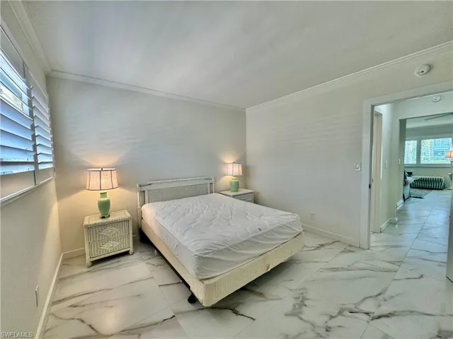 Bedroom featuring tile floors, multiple windows, and crown molding