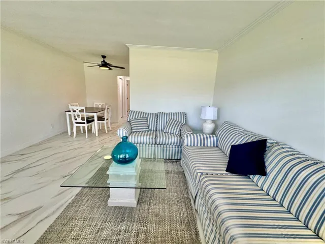 Living room featuring ornamental molding and ceiling fan
