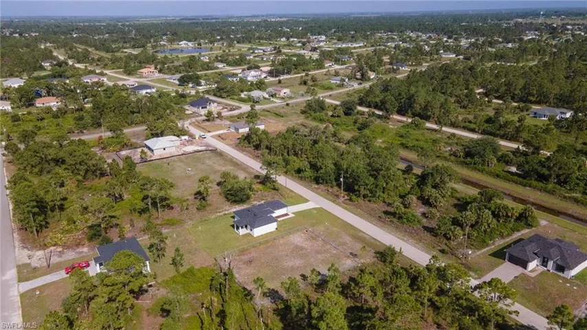 Expansive aerial perspective showcasing a developing residential area with scattered homes and ample green space