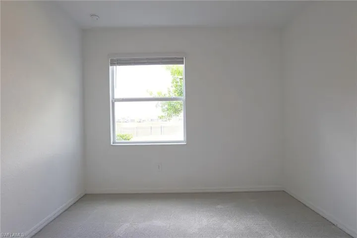 Unfurnished room featuring light colored carpet and baseboards