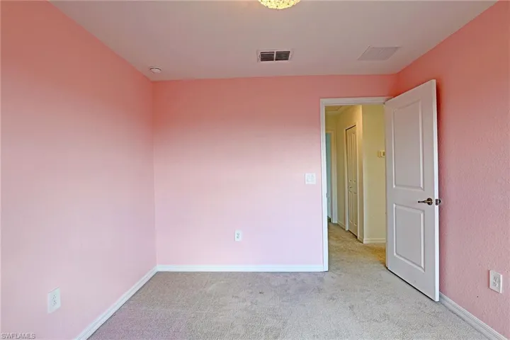 Unfurnished room featuring light colored carpet and baseboards