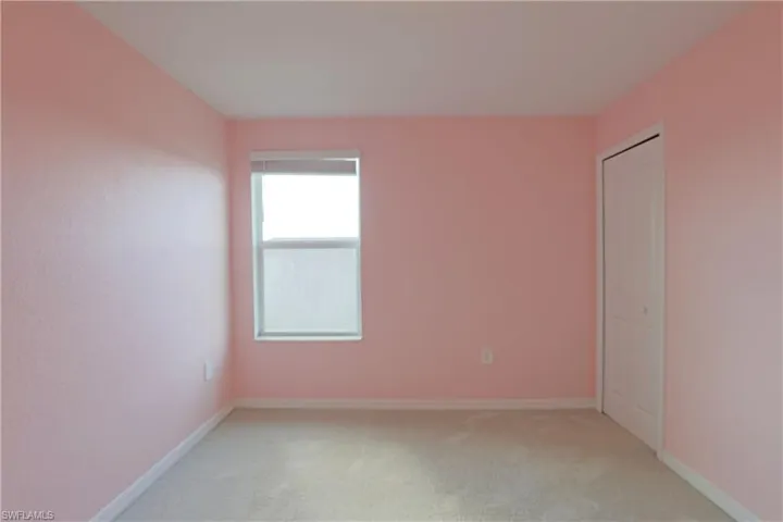 Unfurnished bedroom with light carpet and a closet