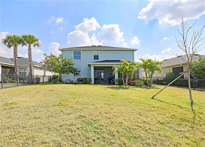 Rear view of house featuring a fenced backyard and a sunroom
