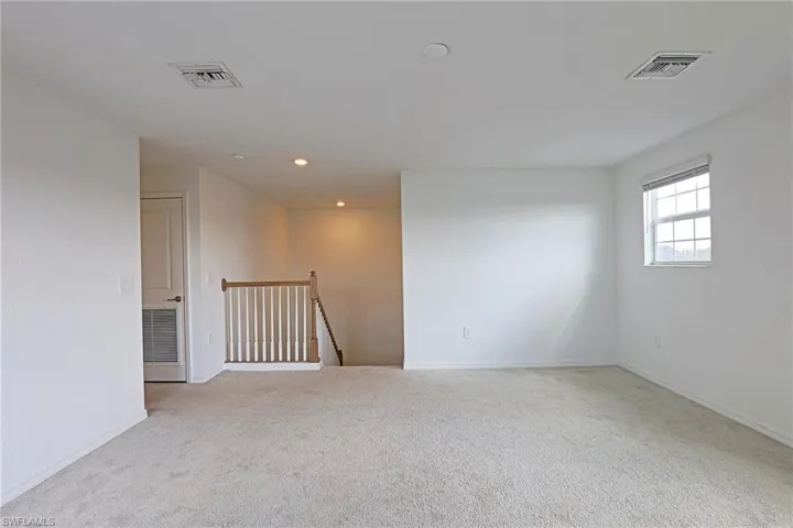 Spare room featuring light colored carpet and recessed lighting