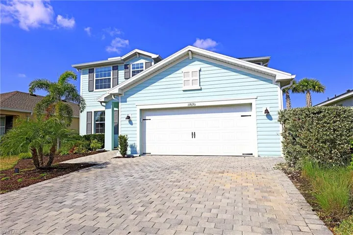 Traditional-style home featuring decorative driveway and an attached garage