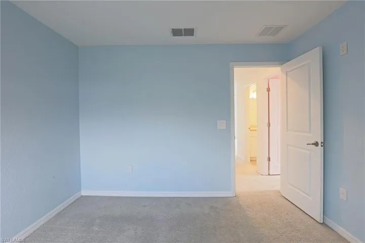 Carpeted spare room featuring baseboards