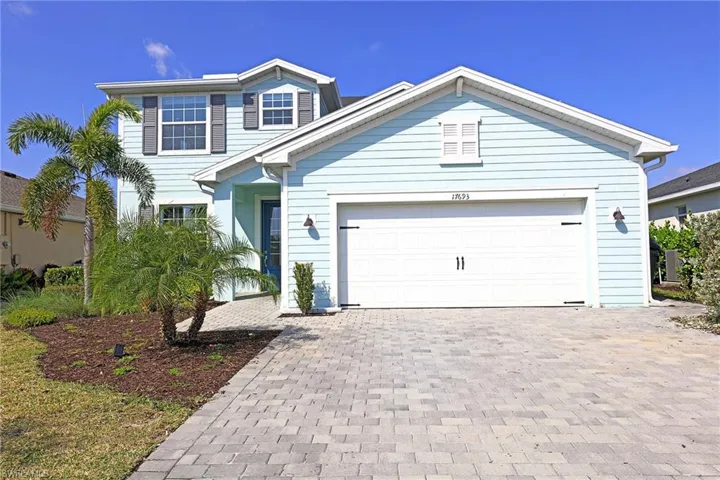 Traditional-style home featuring decorative driveway and a garage