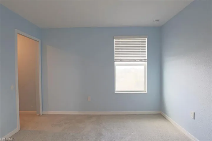 Empty room featuring carpet and baseboards