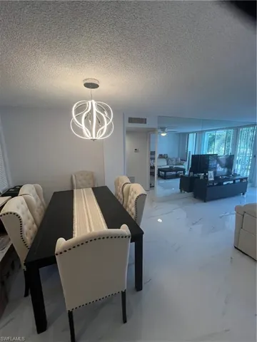 Dining area featuring a textured ceiling and hanging lights