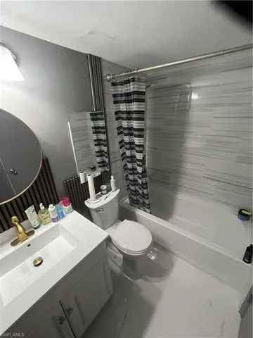 Bathroom with vanity and shower / bath combination with curtain