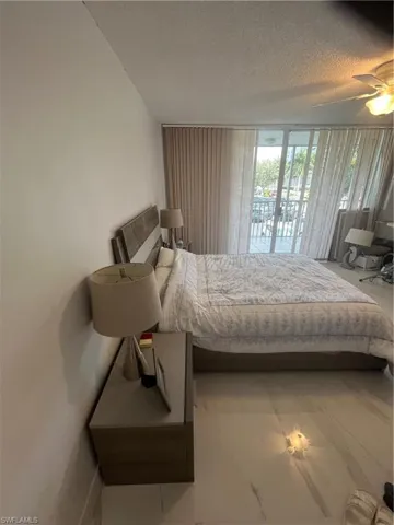 Bedroom featuring a textured ceiling, access to outside, and a ceiling fan