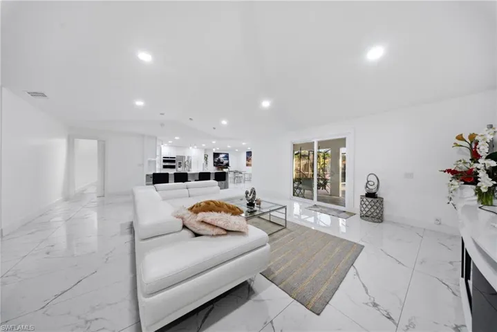 Living area featuring vaulted ceiling and recessed lighting