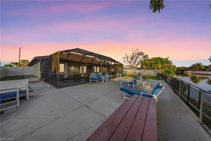 Dock area featuring a fenced backyard, a patio area, glass enclosure, a water view, and a sunroom