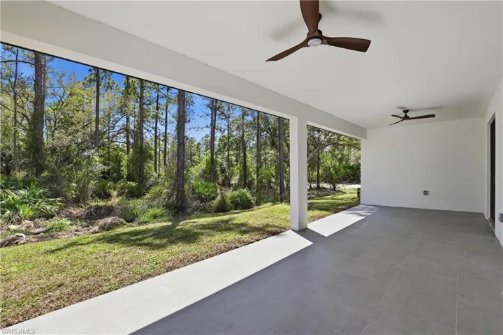 View of patio with ceiling fan and view of scattered trees