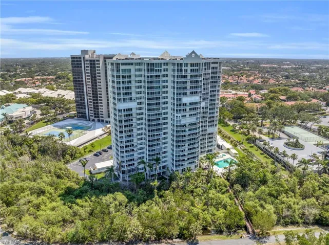 Drone / aerial view of apartment complex / building and a pool area