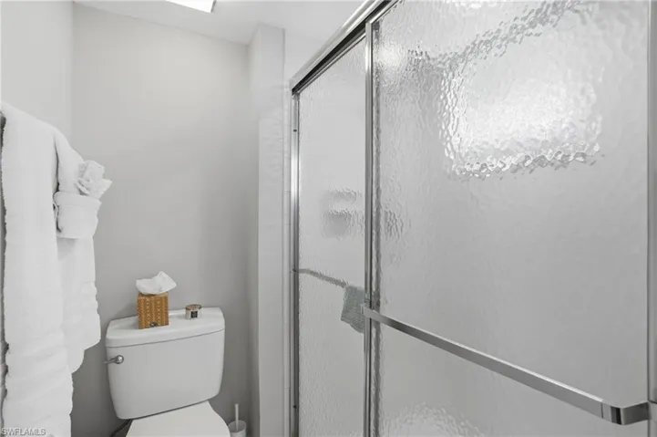 Bathroom with a shower stall and toilet