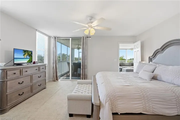 Bedroom with access to exterior, a ceiling fan, and light colored carpet