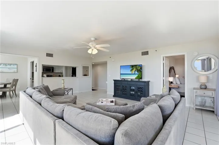 Living room with light tile patterned floors and ceiling fan
