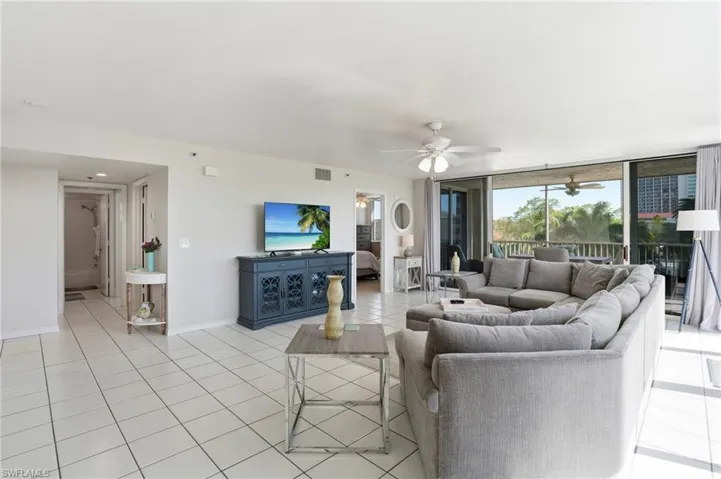 Living room featuring light tile patterned floors and ceiling fan