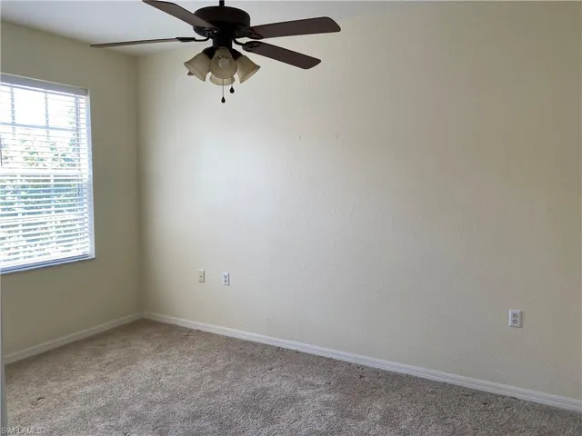 Empty room with ceiling fan and carpet flooring