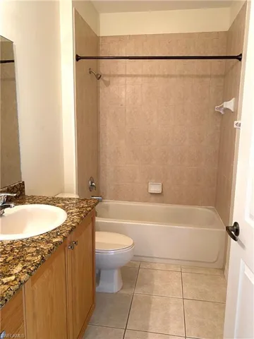 Full bathroom featuring vanity, bathing tub / shower combination, and light tile patterned flooring