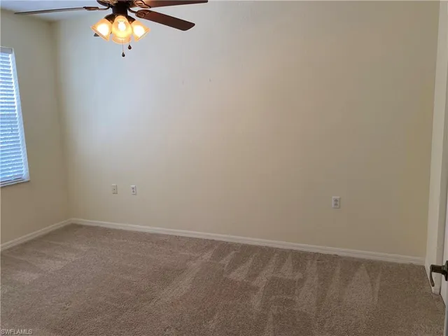 Unfurnished room featuring carpet and a ceiling fan