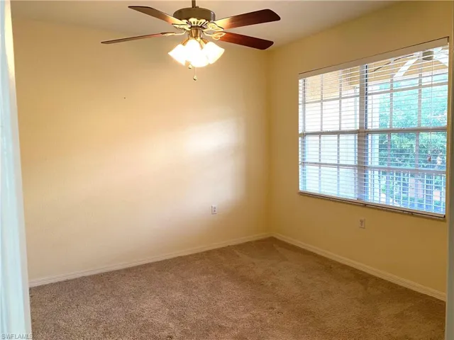 Spare room featuring carpet and a ceiling fan