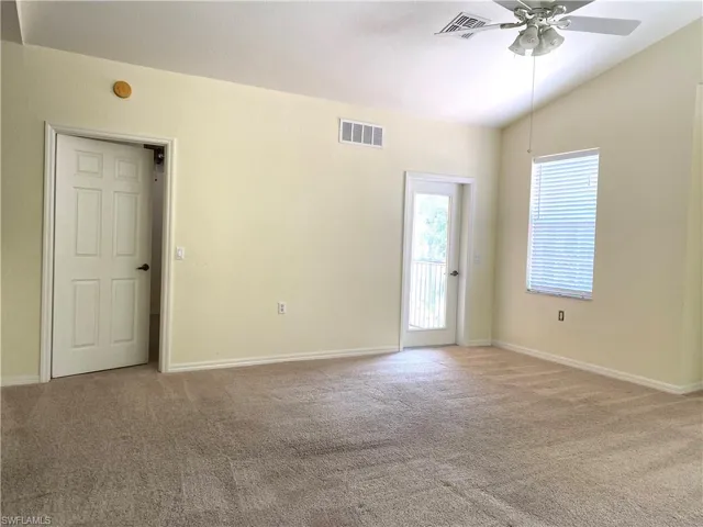 Spare room with light colored carpet, lofted ceiling, and ceiling fan