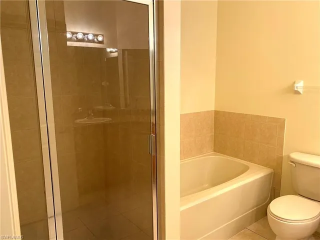 Full bathroom with a bath, a shower stall, and tile patterned flooring