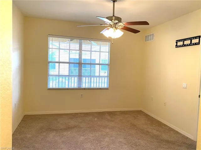 Empty room with carpet floors and a ceiling fan