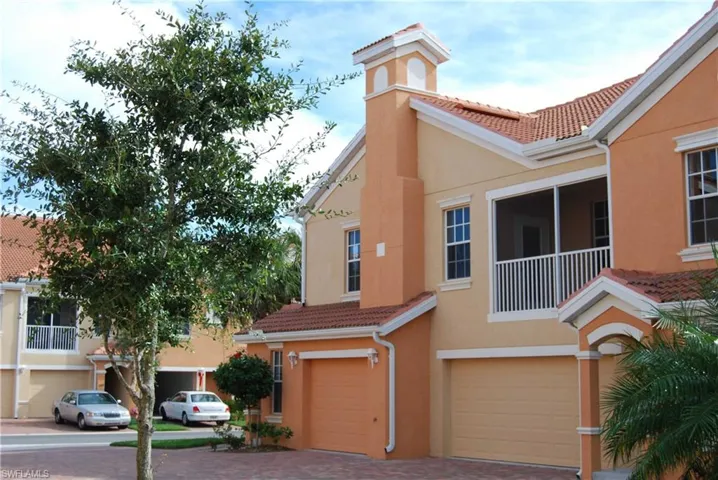 View of front of house with stucco siding, an attached garage, a tile roof, and decorative driveway