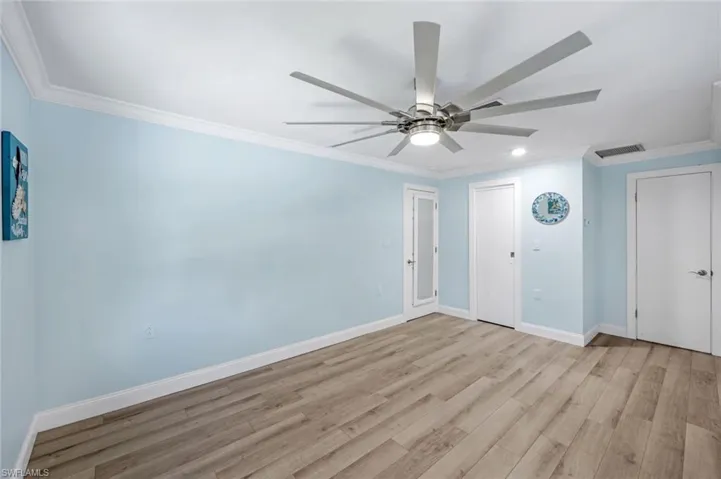 Unfurnished room featuring crown molding, wood finished floors, recessed lighting, and a ceiling fan
